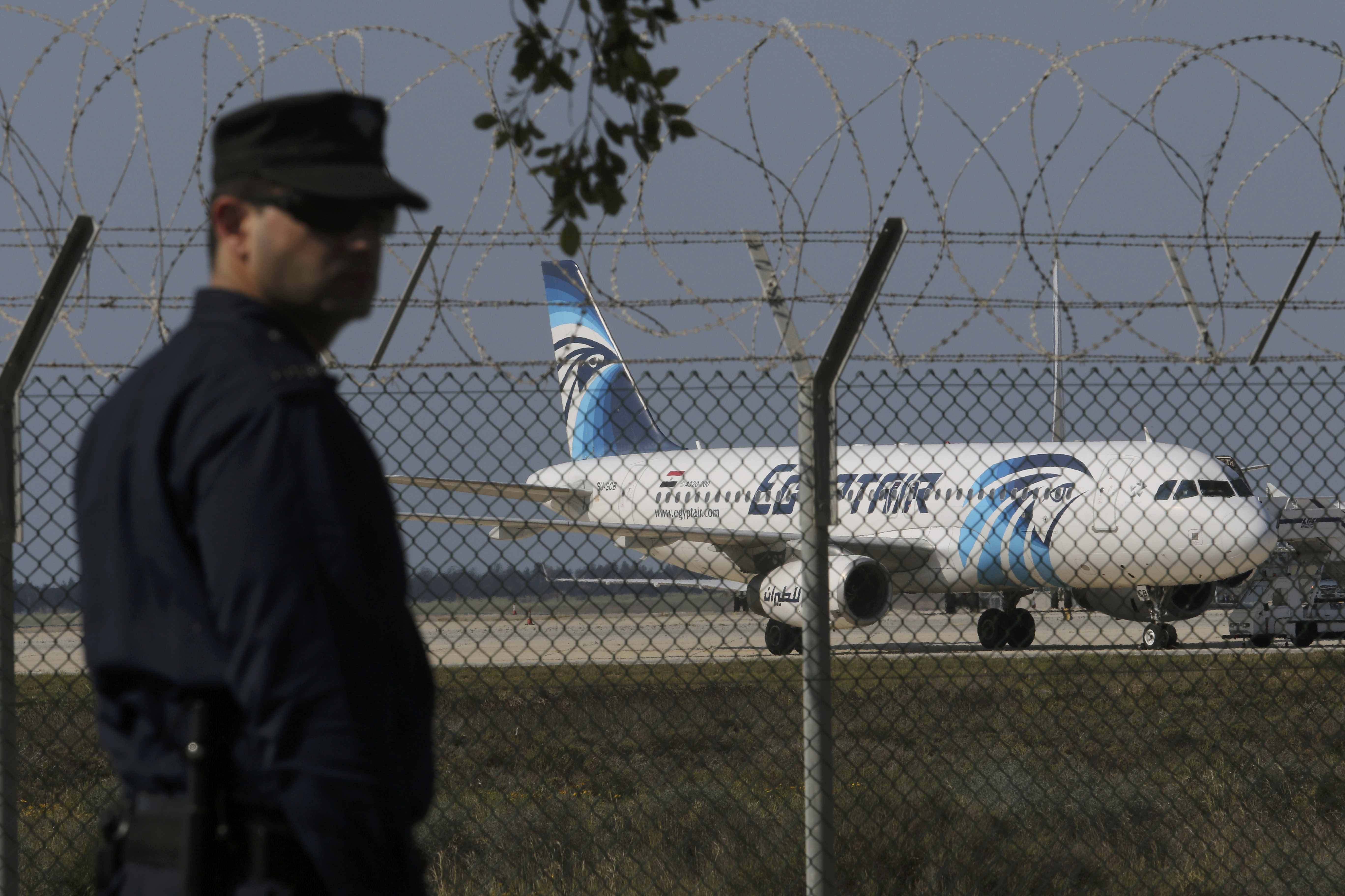 شرطي يقف حارسا في مطار لارنكا بالقرب من A320 مصر للطيران المخطوفة