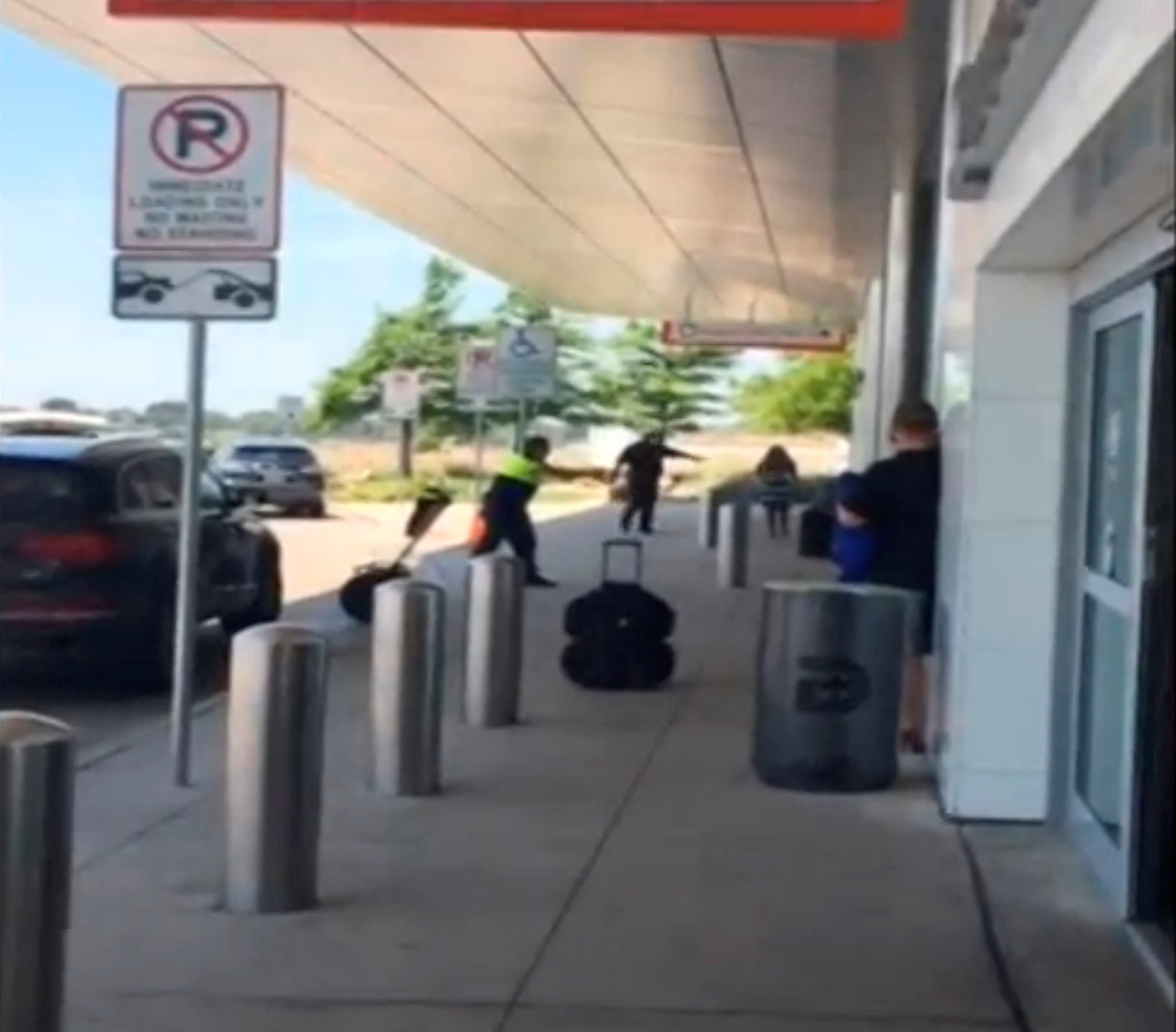 Still image of a police officer aiming his weapon after opening fire on a man who authorities say was involved in a domestic dispute at Love Field in Dallas